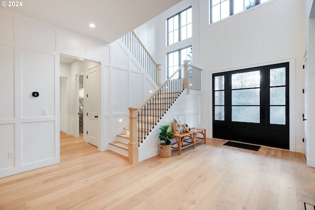 foyer entrance with light hardwood / wood-style flooring and a high ceiling