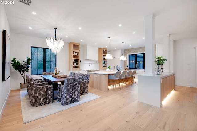 interior space featuring an inviting chandelier, sink, and light hardwood / wood-style floors