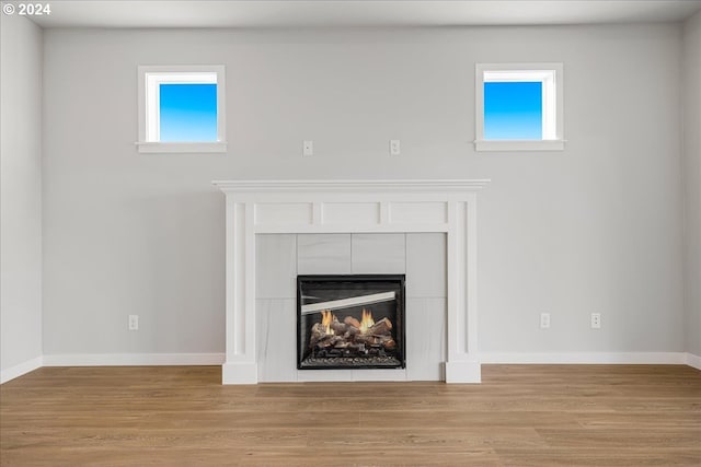 details with hardwood / wood-style floors and a tile fireplace