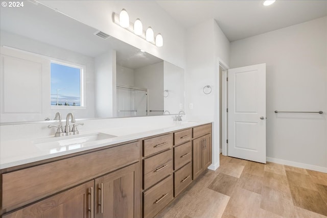 bathroom featuring vanity, hardwood / wood-style flooring, and a shower with door