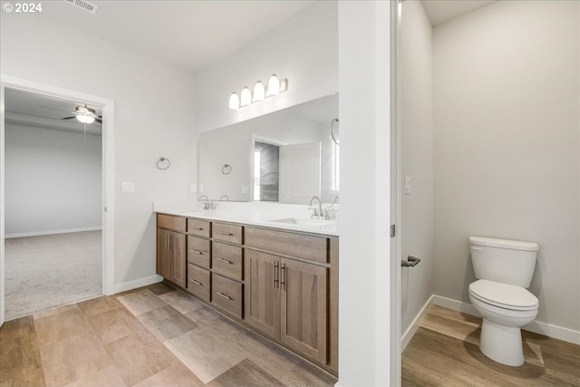 bathroom with toilet, vanity, and ceiling fan