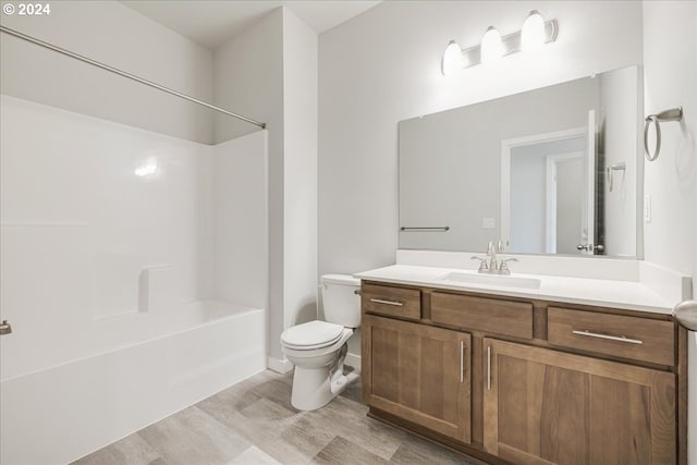 full bathroom with toilet, vanity,  shower combination, and wood-type flooring