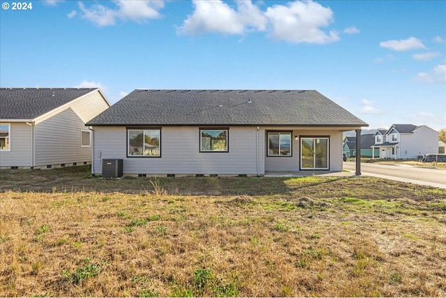 rear view of property featuring central AC and a yard