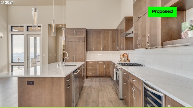 kitchen featuring beverage cooler, decorative light fixtures, premium appliances, light wood-type flooring, and sink