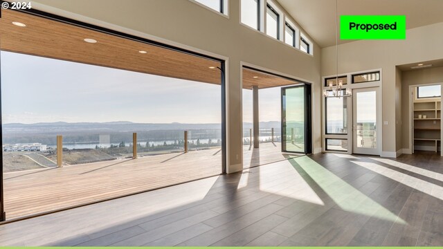 empty room featuring hardwood / wood-style floors, a mountain view, and an inviting chandelier