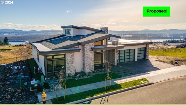 view of front of home with a garage, central AC, and a mountain view