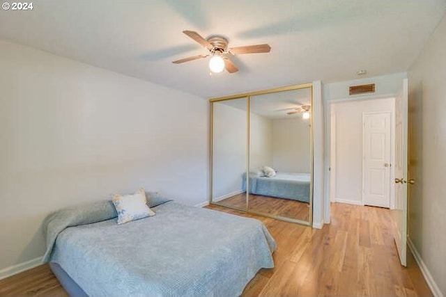 bedroom featuring hardwood / wood-style floors, ceiling fan, and a closet