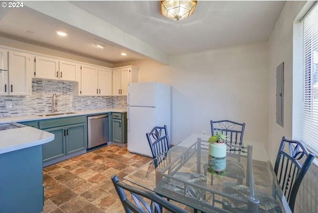 kitchen with dishwasher, sink, tasteful backsplash, white fridge, and white cabinets