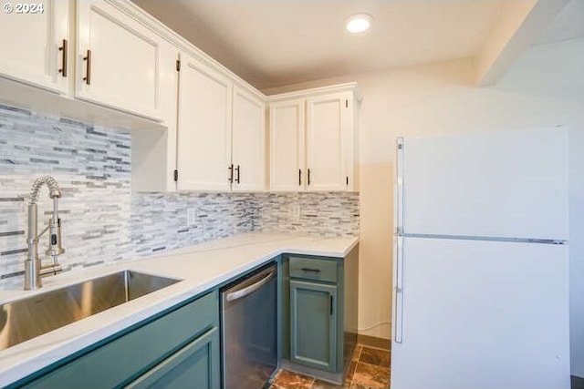 kitchen featuring white cabinets, sink, stainless steel dishwasher, tasteful backsplash, and white fridge