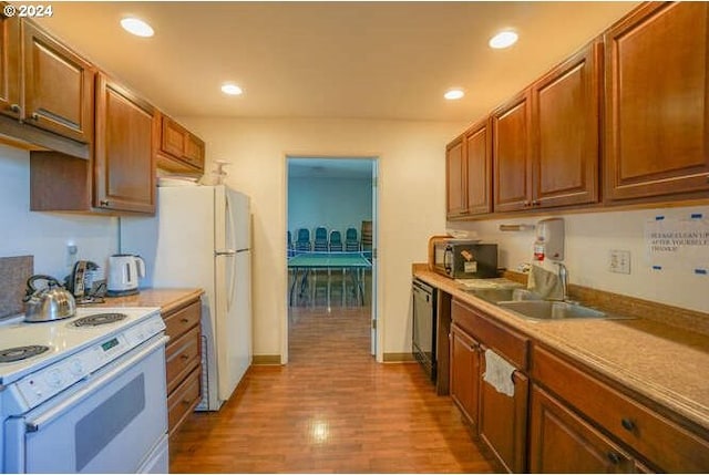 kitchen with white appliances, light hardwood / wood-style flooring, and sink