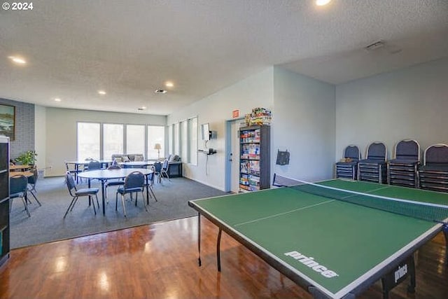 game room with wood-type flooring and a textured ceiling