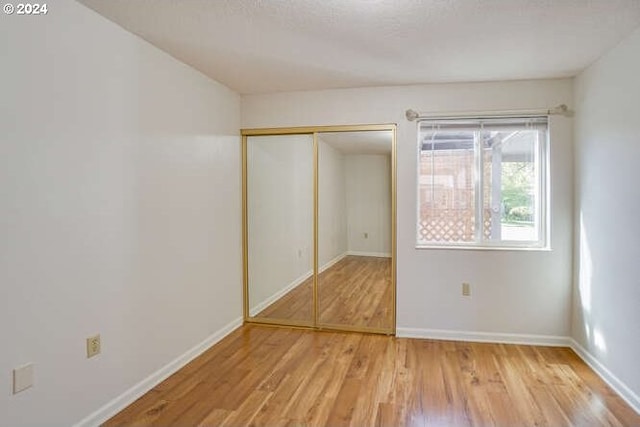 unfurnished bedroom featuring hardwood / wood-style flooring and a closet