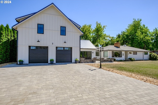 modern inspired farmhouse featuring a garage and a front lawn