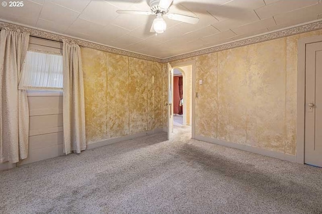 unfurnished room with ornamental molding, carpet floors, and ceiling fan