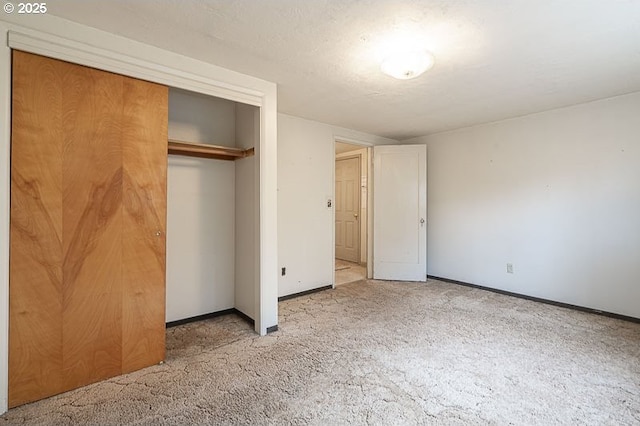 unfurnished bedroom with carpet floors, a textured ceiling, and a closet