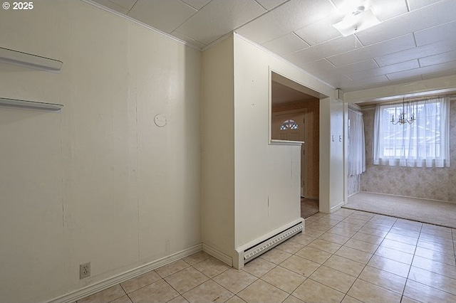 spare room with ornamental molding, a baseboard heating unit, and light tile patterned floors