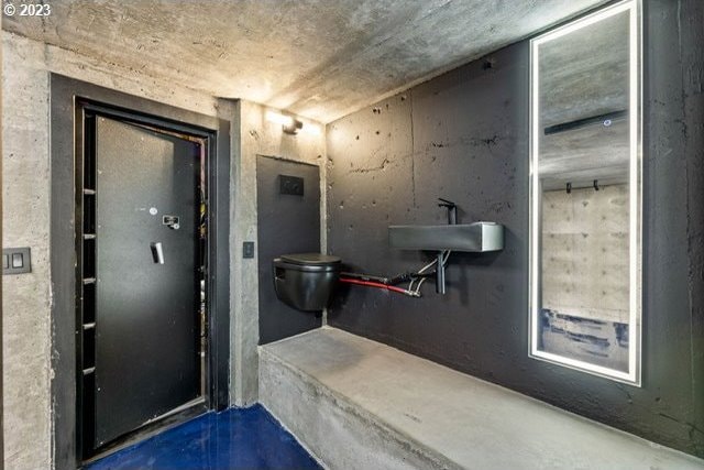 bathroom with toilet and concrete floors