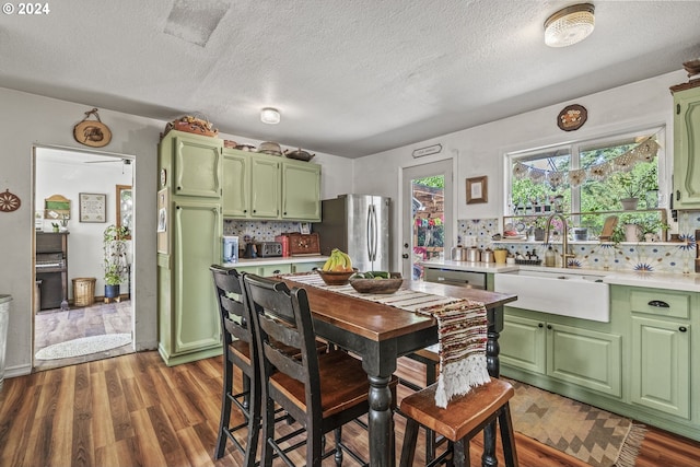 dining room featuring sink, dark wood-type flooring, and a textured ceiling