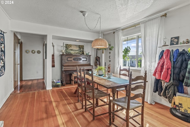 dining space with a textured ceiling and hardwood / wood-style flooring