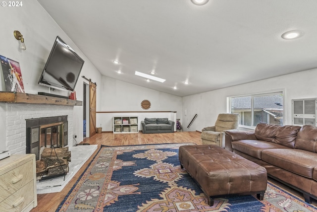 living room featuring hardwood / wood-style flooring, lofted ceiling, and a fireplace