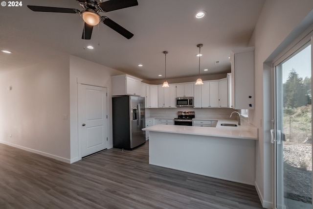 kitchen with white cabinetry, dark hardwood / wood-style flooring, decorative light fixtures, and appliances with stainless steel finishes