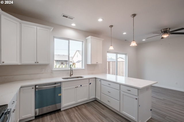 kitchen featuring dishwasher, sink, kitchen peninsula, pendant lighting, and white cabinets