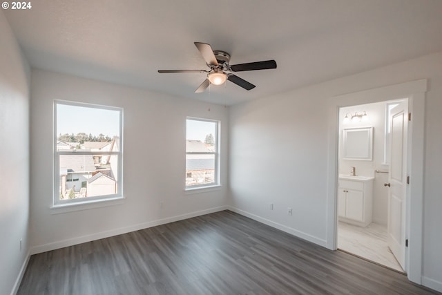 unfurnished bedroom with ensuite bath, ceiling fan, dark hardwood / wood-style flooring, and sink