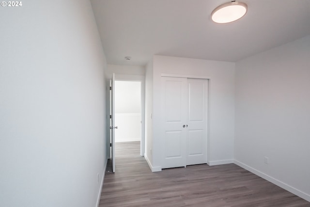 unfurnished bedroom with light hardwood / wood-style floors and a closet