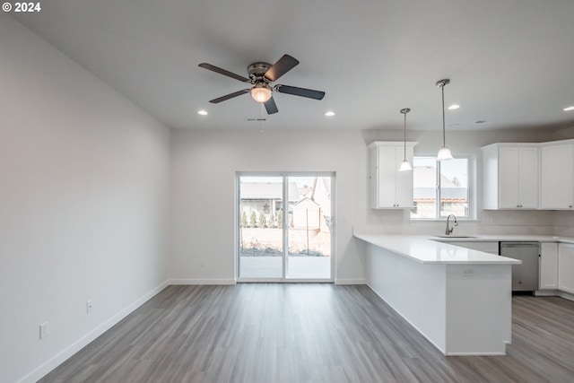 kitchen featuring white cabinetry, kitchen peninsula, a wealth of natural light, and sink