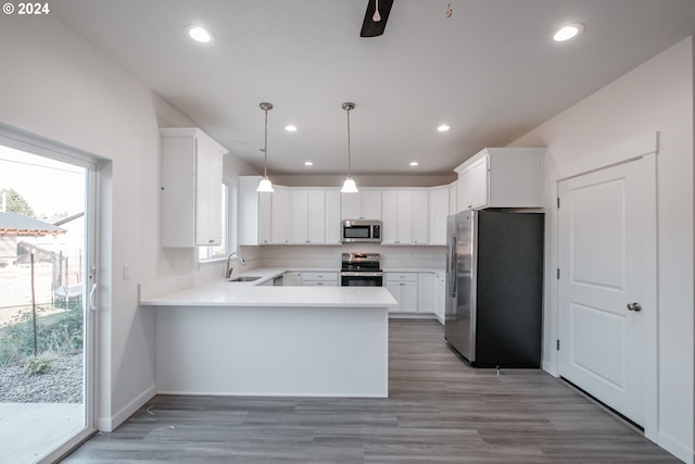 kitchen featuring white cabinets, decorative light fixtures, stainless steel appliances, and sink