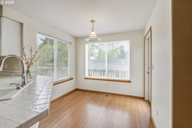4135 SW Brugger St, Portland, OR 97219 - unfurnished dining area with a sink and light wood finished floors