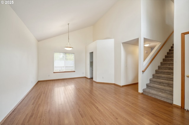 4135 SW Brugger St, Portland, OR 97219 - unfurnished living room with high vaulted ceiling, light wood-style flooring, and stairway