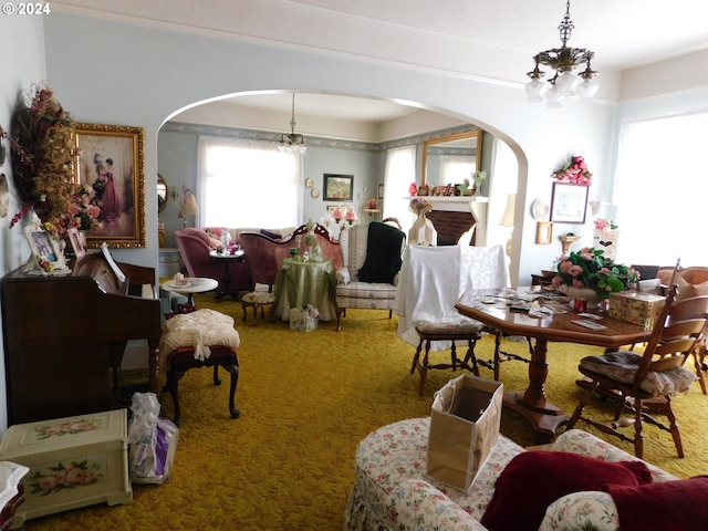 carpeted living room with a notable chandelier