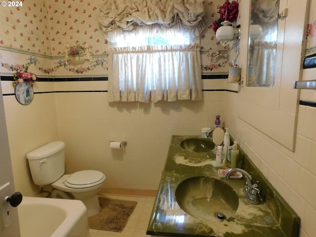 bathroom featuring vanity, toilet, a tub, tile walls, and tile patterned flooring