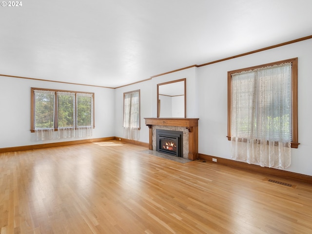 unfurnished living room with crown molding, light hardwood / wood-style floors, and a high end fireplace