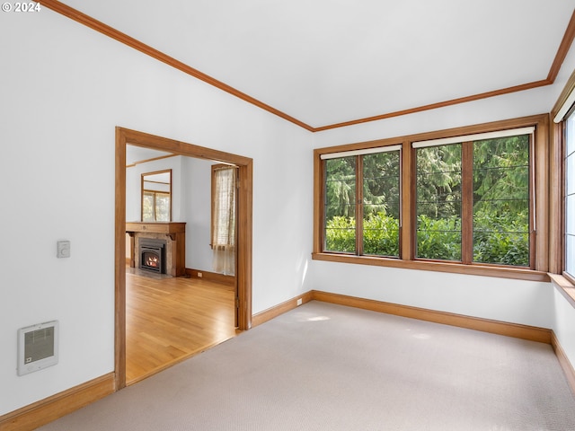 empty room with light carpet, a healthy amount of sunlight, and ornamental molding