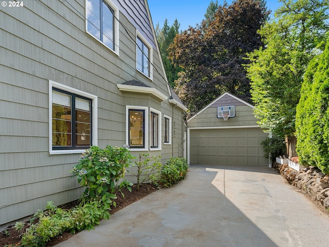 view of home's exterior with a garage and an outbuilding