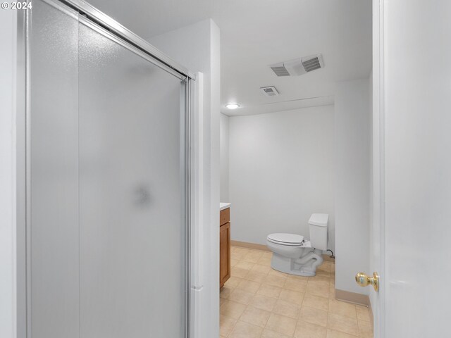 bathroom featuring toilet, vanity, and walk in shower