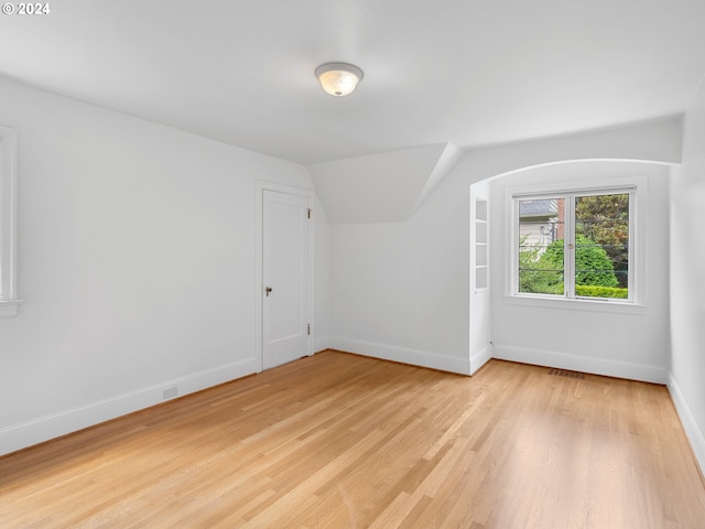 bonus room featuring light wood-type flooring and lofted ceiling