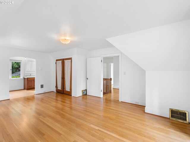 additional living space featuring light hardwood / wood-style flooring and vaulted ceiling