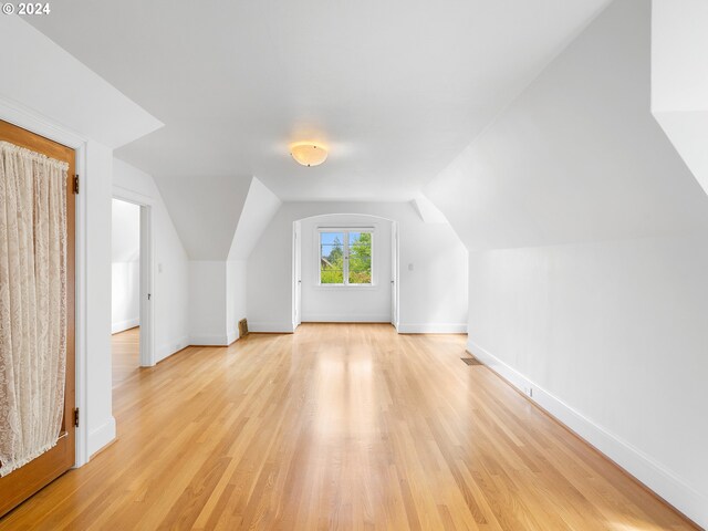 bonus room with light hardwood / wood-style flooring and vaulted ceiling