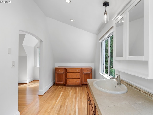 bathroom featuring vaulted ceiling, wood-type flooring, and vanity