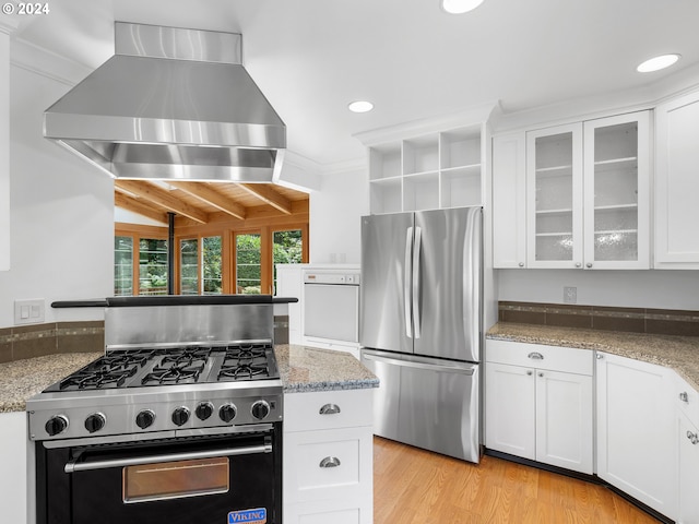 kitchen featuring wall chimney range hood, stainless steel refrigerator, beam ceiling, gas range, and light hardwood / wood-style floors