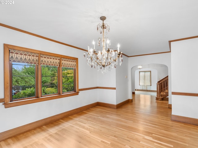 spare room featuring light hardwood / wood-style flooring, a notable chandelier, and crown molding