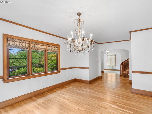 spare room with light wood-type flooring and ornamental molding