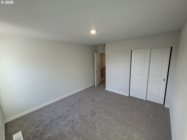 unfurnished bedroom with carpet, a closet, visible vents, and baseboards