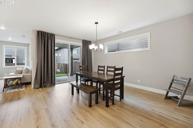 dining space featuring an inviting chandelier and light wood-type flooring