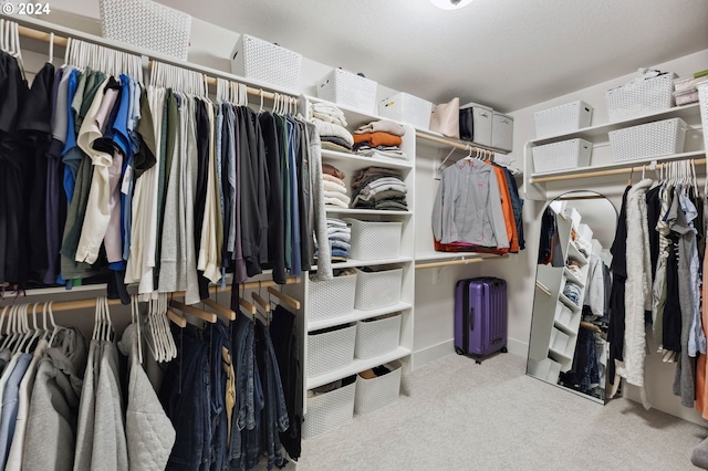 walk in closet featuring light carpet