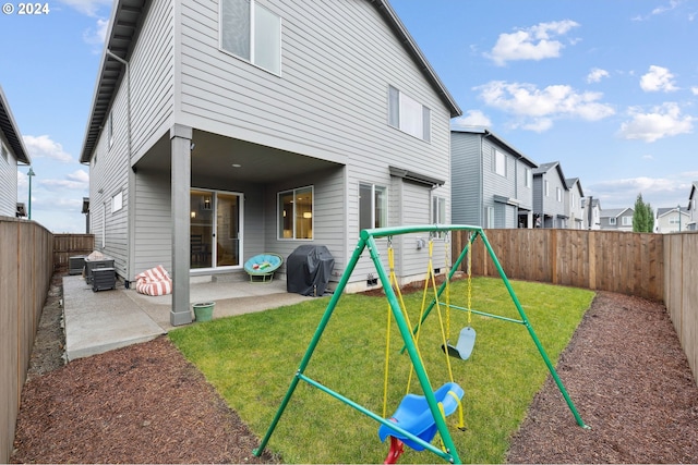 back of house with a playground, a patio, and a lawn