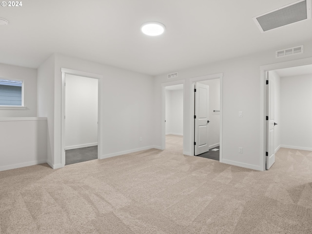 interior space with ensuite bath, light carpet, and a closet